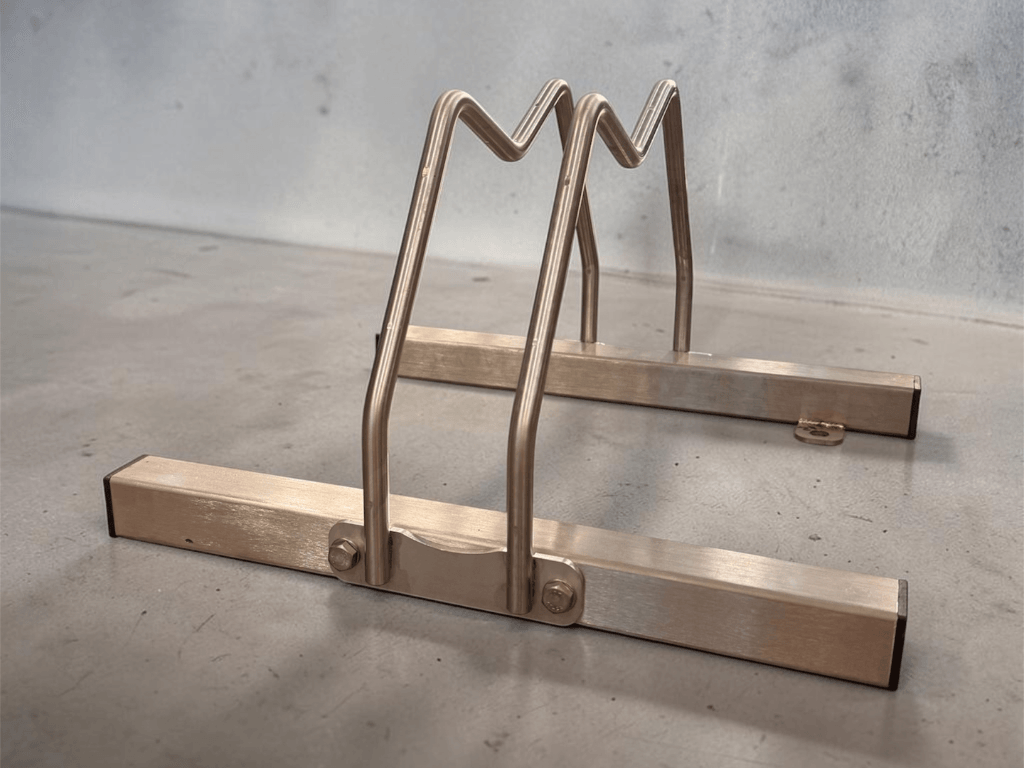 Porta bicicletta singolo in acciaio inox 304 satinato, modello base Slimec Inox predisposto per il fissaggio a terra.