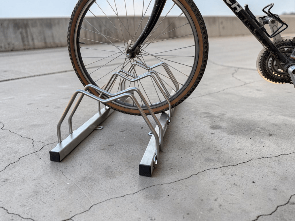 Dettaglio del sistema di bloccaggio della ruota di una bicicletta all'interno del porta biciclette in acciaio inox AISI 304.
