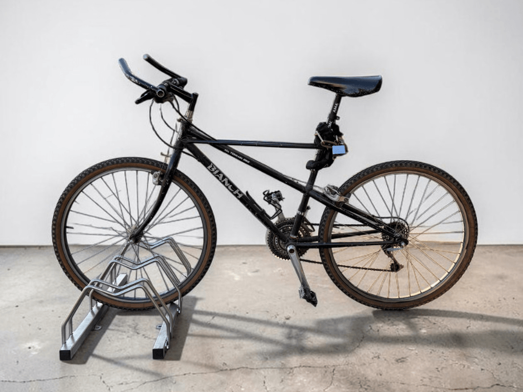 Rastrelliera per biciclette in acciaio inox 304 Slimec Inox con una mountain bike posizionata nel modulo di parcheggio.